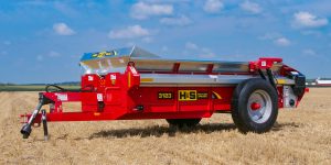H&S 3123 heavy duty manure spreader in a field with jack down