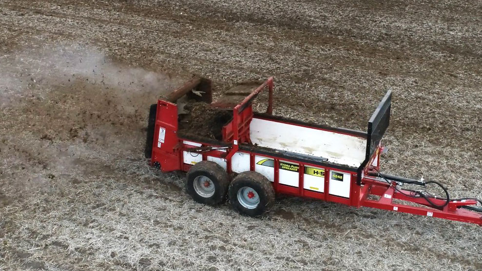 H&S hydra push 4242 vertical beater manure spreader spreading manure onto a field