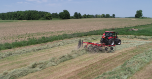 H&S 3210 10-wheel action rake raking hay in a field