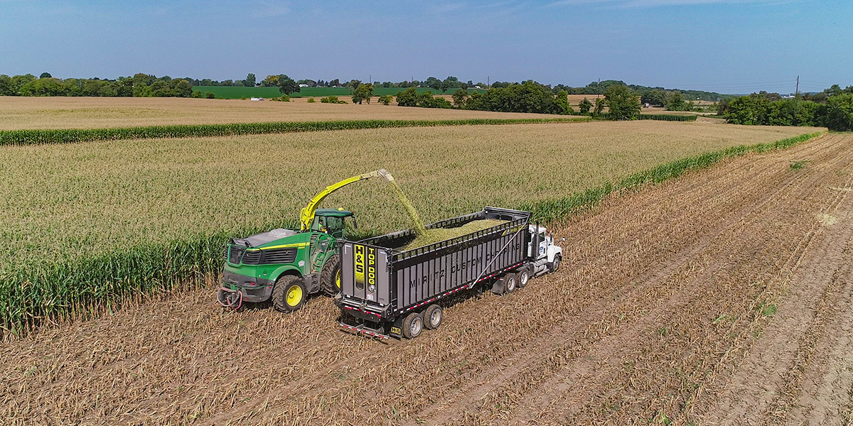 H&S 1238 Top Dog rear unload forage box collecting material in the field