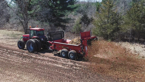 H&S 6138 PowerSpread manure spreader spreading onto a field