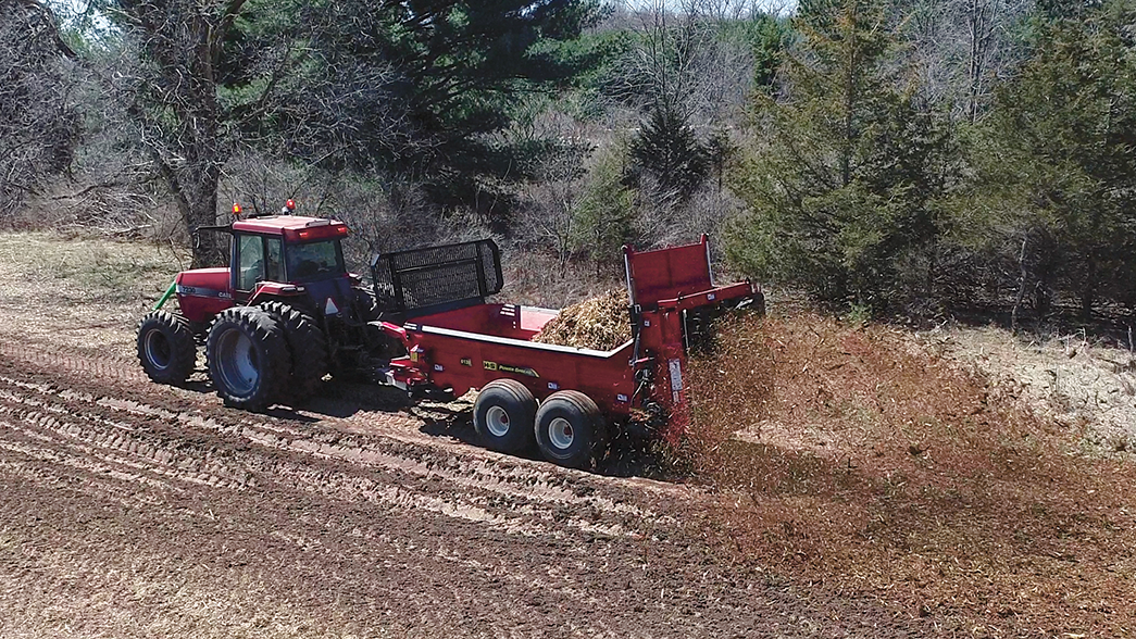 H&S 6138 PowerSpread manure spreader spreading onto a field